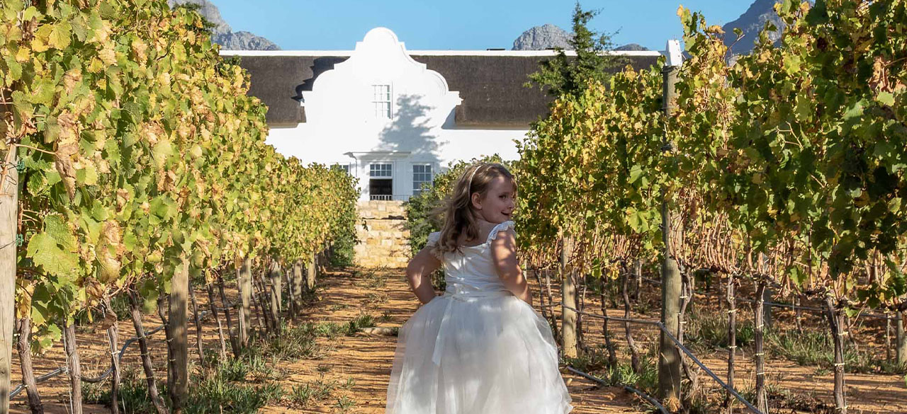 A young girl runs through the vines surrounding Brookdale Manor House in Paarl. 