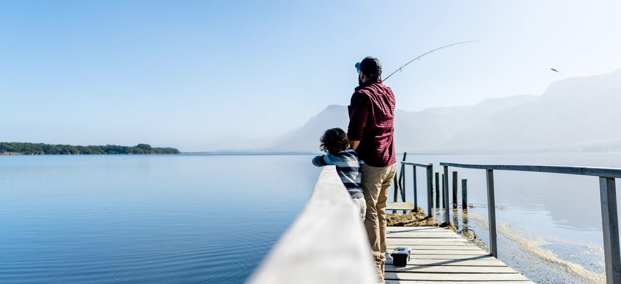 A father and son fishing off the pier at Perivoli Lagoon House in Hermanus